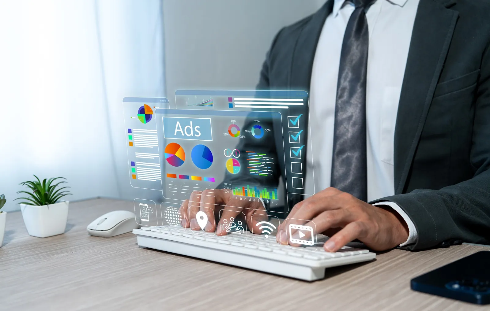 Business person at a keyboard with ad performance charts shown above it