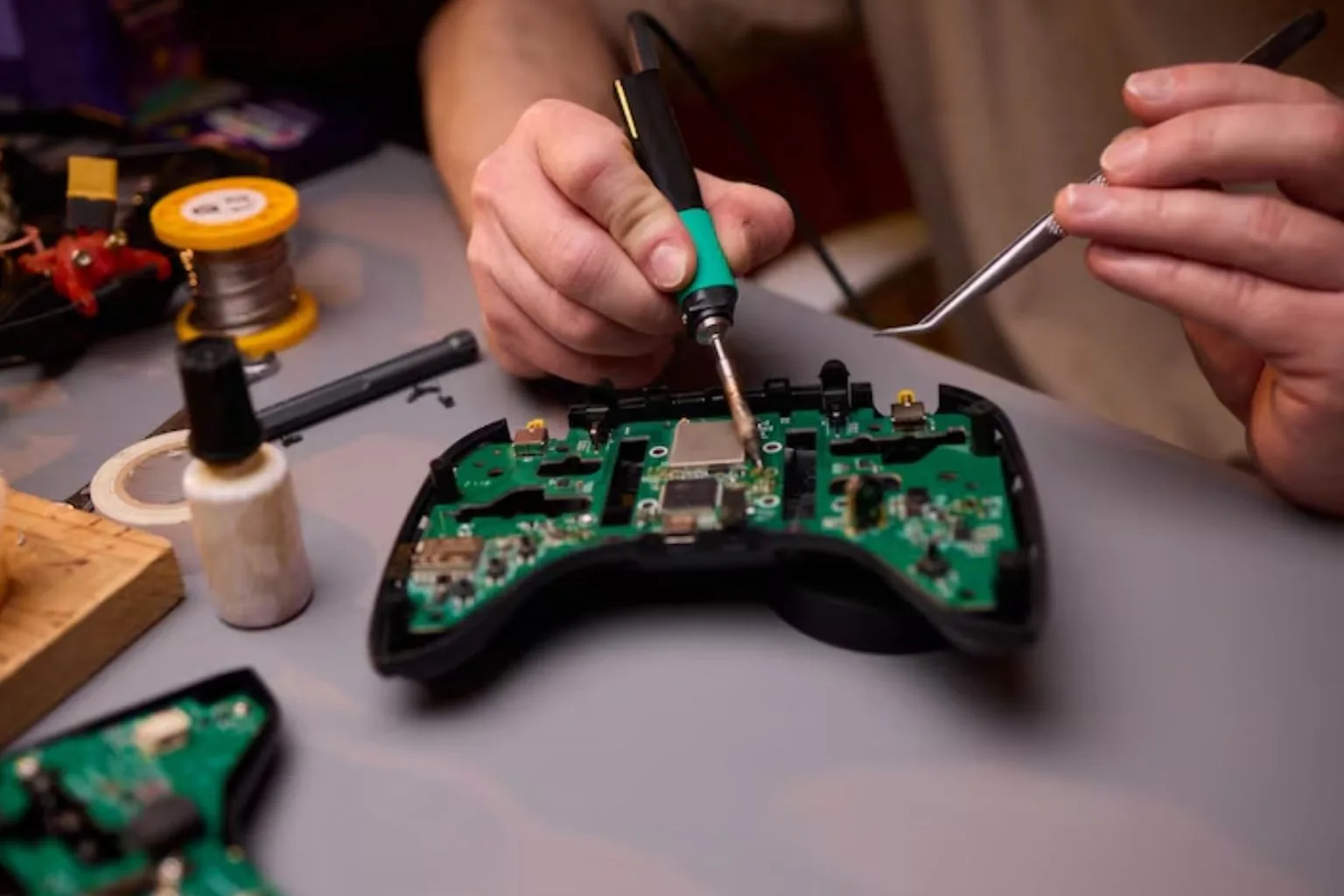 Technician repairing a game console on a repair bench in Greensboro, NC