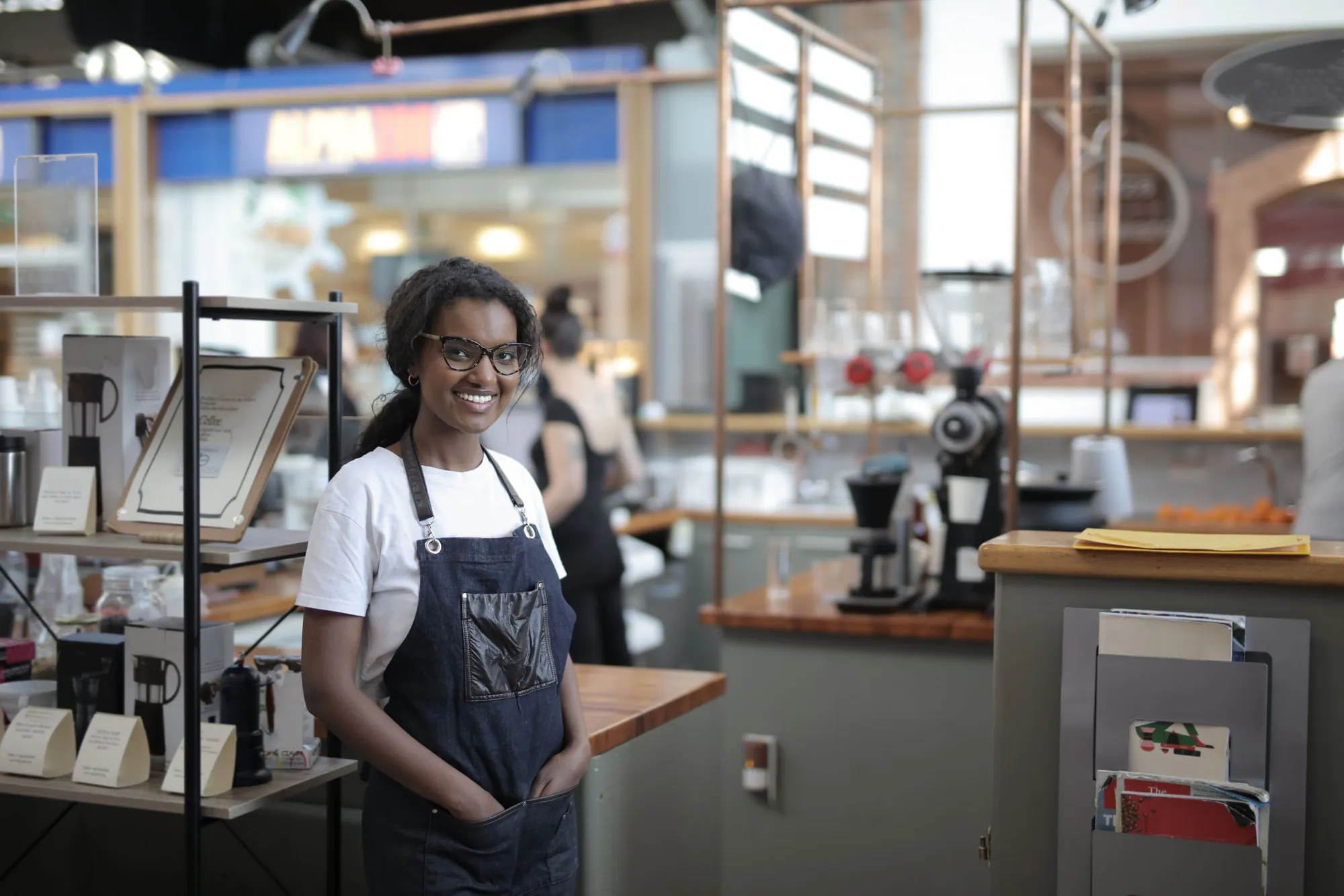 Smiling owner standing in her local coffee shop