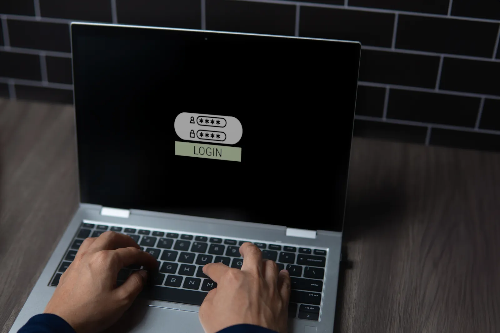 Employee signing in on a laptop login screen with help desk support behind them