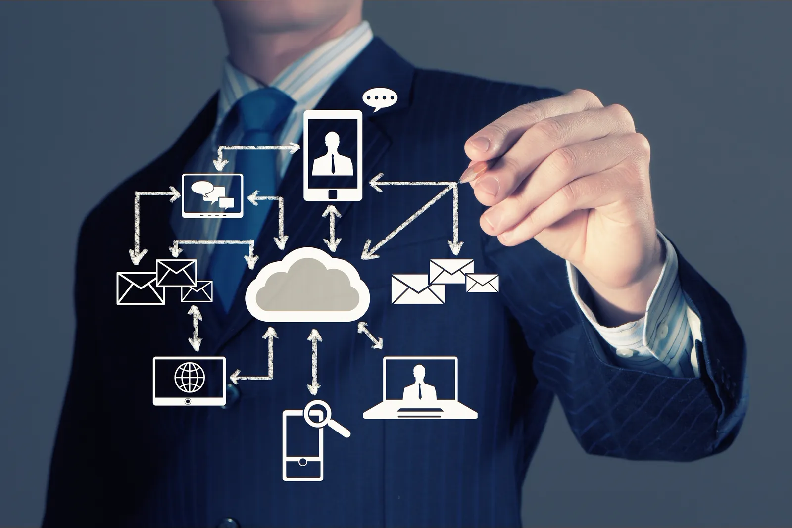 Business person drawing a cloud network that connects email, phones and computers