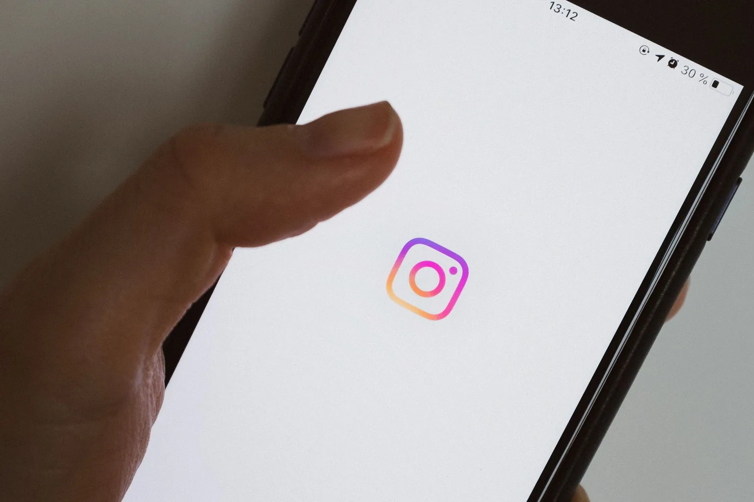 Phone opening the Instagram app for a Greensboro, NC business ad campaign